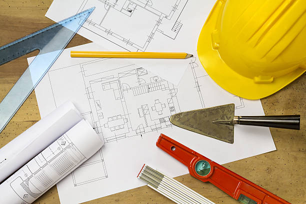 istock Protective helmet, mason tools and project drawings on wood background 635781636