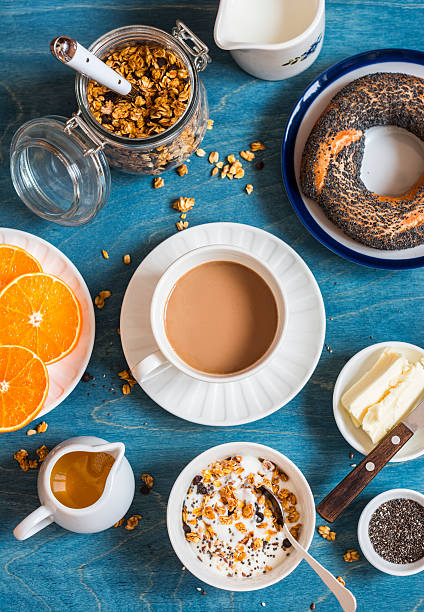 istock Yogurt, pumpkin granola, bagel, butter on a blue table. 635784808