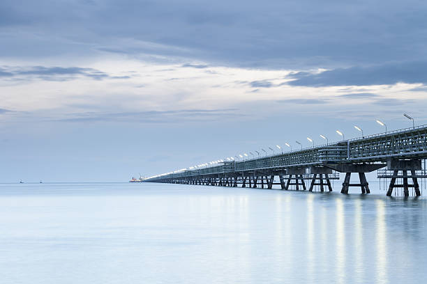 istock Long pipeline with Gas transport ship on port 635785546
