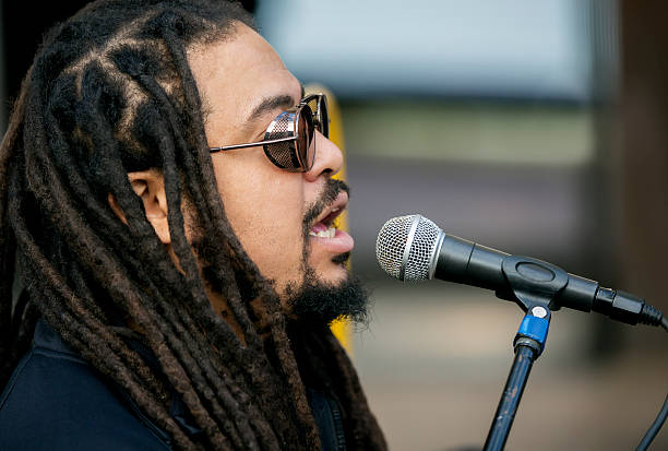 istock Cool singer with dreadlocks in front of mike 635786826
