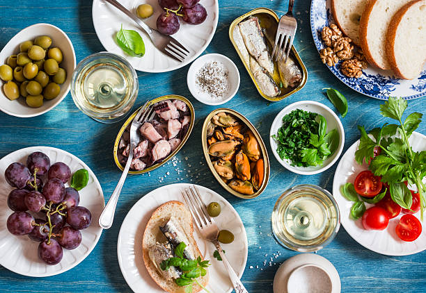 istock Seafood snacks - sardines, mussels, octopus, grape, olives, white wine 635787870