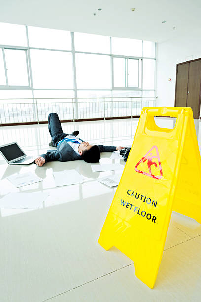 istock Businessman slipped on a floor next to caution sign 635788592