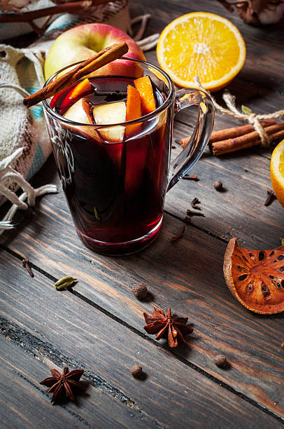 istock Hot mulled wine with spices, apple and orange on wood 635788838