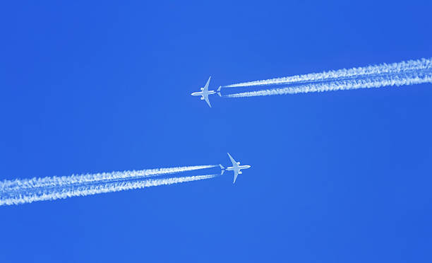 istock two planes flying high in the sky meet 635792044