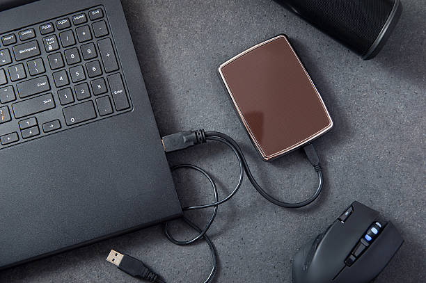 istock Laptop with connected portable hard drive. 635792204