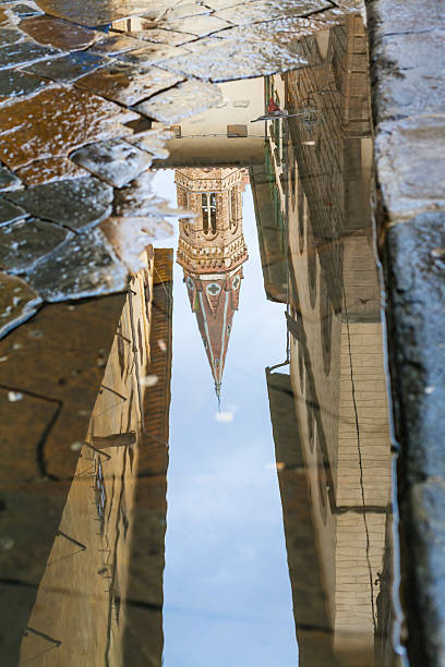 istock tower of church reflected in puddle 635796740