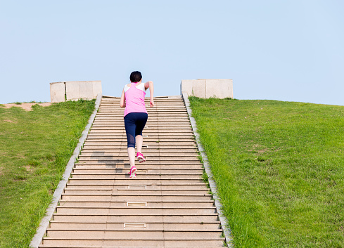 Young woman running at stone stairs.