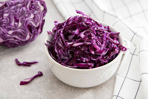 istock Shredded red cabbage in clay bowl on stone background. 635798568