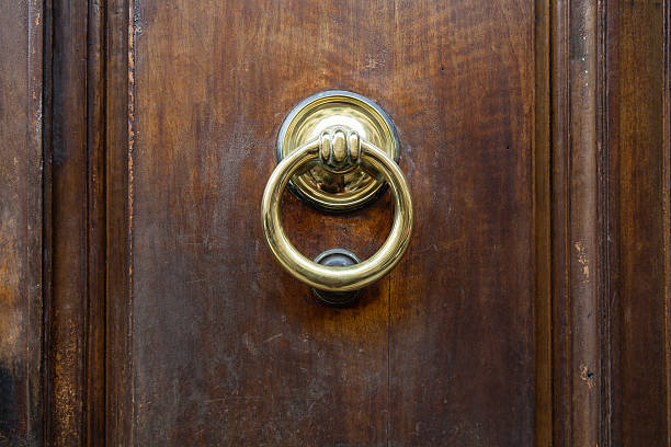 istock brass ring knocker on old wooden door in Florence 635799630
