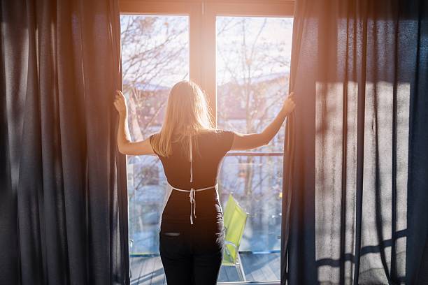 istock Hotel maid opening window curtains 635800744