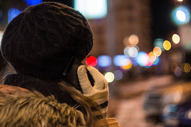 istock Young woman talking on mobile phone at night in winter 635806018