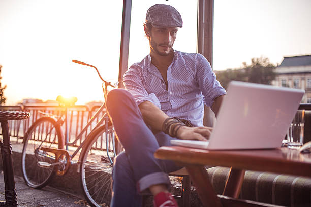 istock Man in cafe works on laptop 635807706