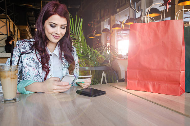 Girl sits at the table and buys over the Internet