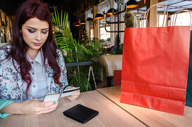 istock Girl sits at the table and buys over the Internet 635807766