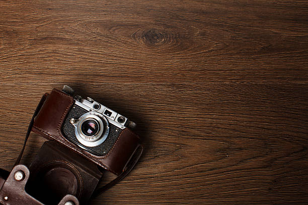 istock Retro camera on wooden background 635809032