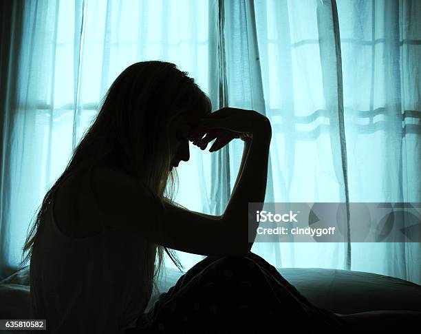 Silhouette Of Woman Sitting In Bed By Window Stock Photo - Download Image Now - Women, Depression - Sadness, In Silhouette