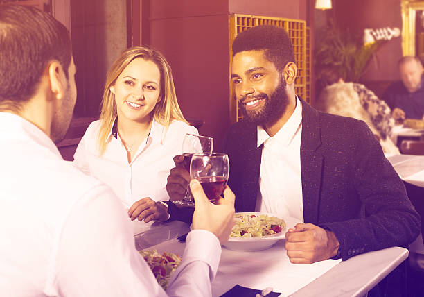 istock friends eating at restaurant table and chatting 635810986