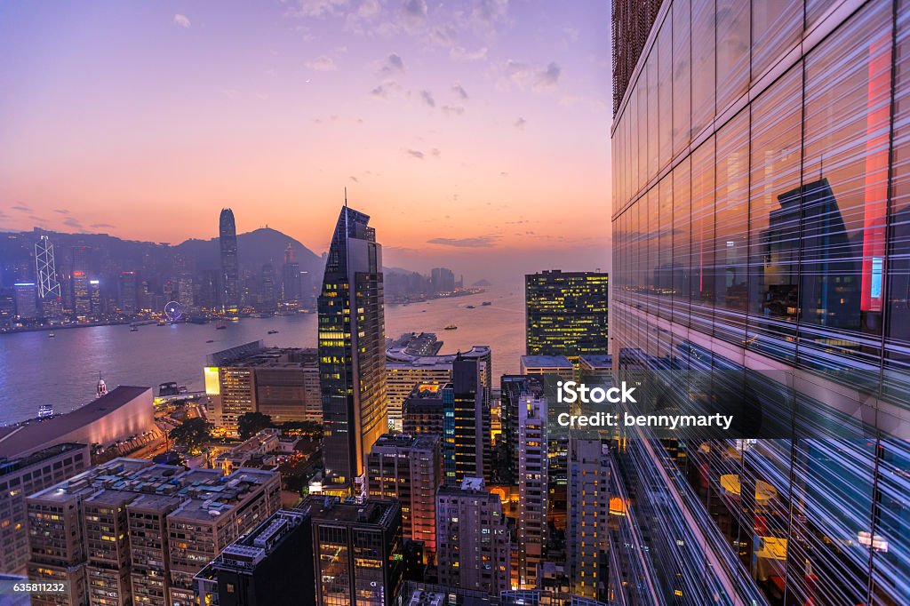 Hong Kong aerial by night Spectacular aerial view of Victoria Harbor, skyscrapers and Hong Kong skyline at night. Skyline reflected in glass facade of a modern building. Hong Kong Stock Photo