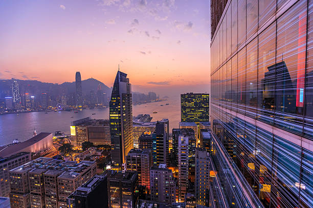 Hong Kong aerial by night Spectacular aerial view of Victoria Harbor, skyscrapers and Hong Kong skyline at night. Skyline reflected in glass facade of a modern building. hong kong photos stock pictures, royalty-free photos & images
