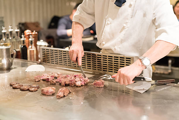 istock teppanyaki chef cooking and cutting steak 635812958