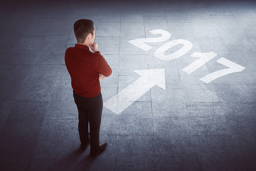 Back view of  asian businessman standing on the floor with year 2017 printed on it