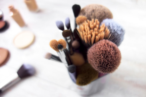 looking down on make up brushes on a wooden table