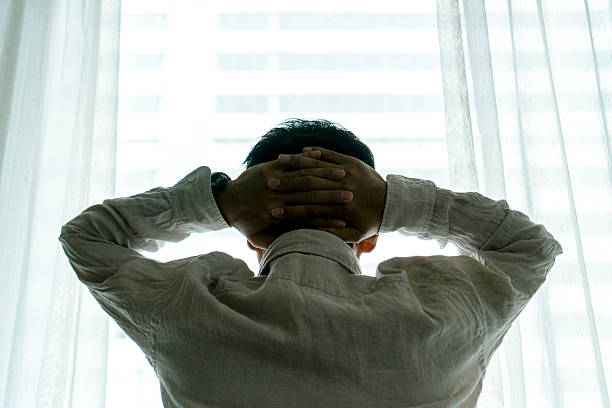 istock man looking out in front of window 635828536
