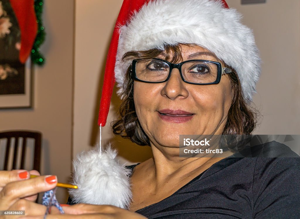 Feliz navidad senior hispanic woman in Christmas hat Adult Stock Photo
