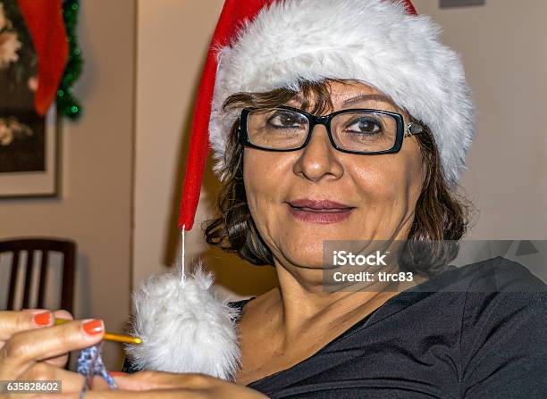 Feliz Navidad Senior Hispanic Woman In Christmas Hat Stock Photo - Download Image Now