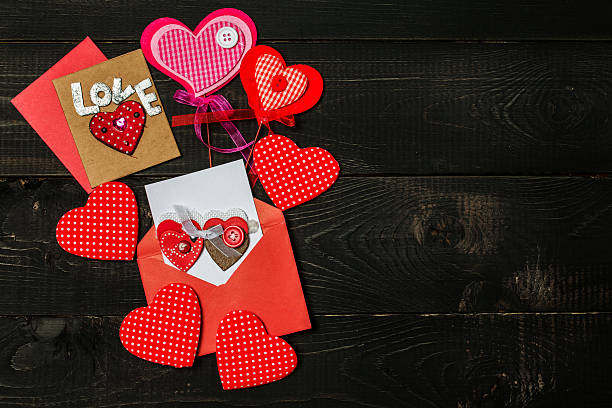 istock Love hearts on black wooden background 635829408