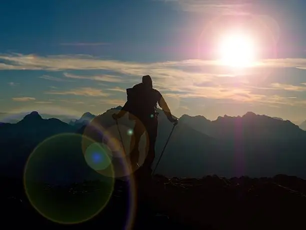 Photo of Lens flare. Hiker takes selfie photo. Tourist at peak