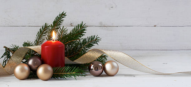 istock Red burning candle with christmas decoration on white wood 635832542