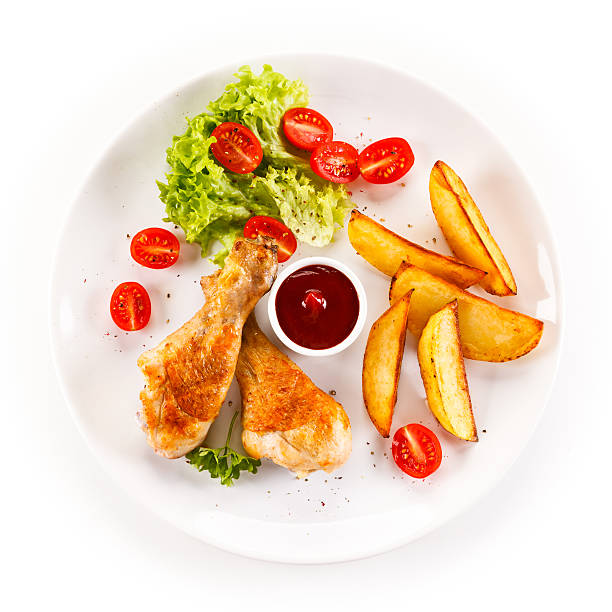istock Roasted chicken drumsticks, backed potatoes and vegetables 635832794