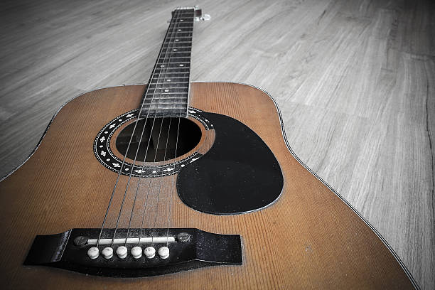 istock Old guitar on the wooden floor. 635837834