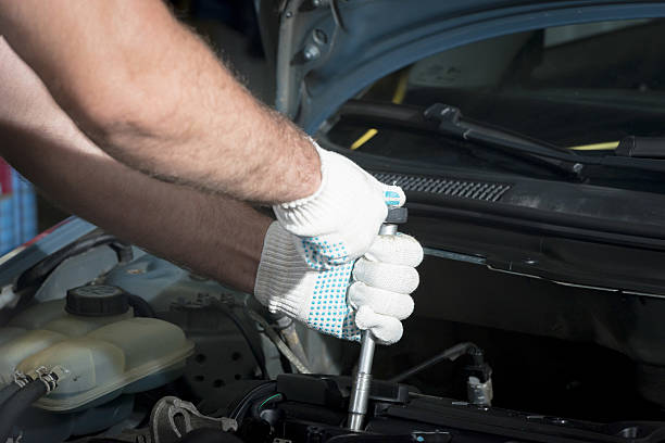 istock Hands of car mechanic with a wrench 635838100