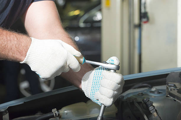 istock Hands of car mechanic with a wrench 635838128