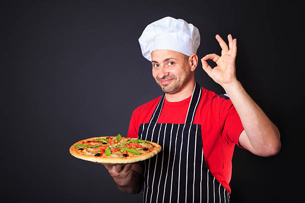 Retrato de feliz y atractiva cook con una pizza en las manos - foto de stock