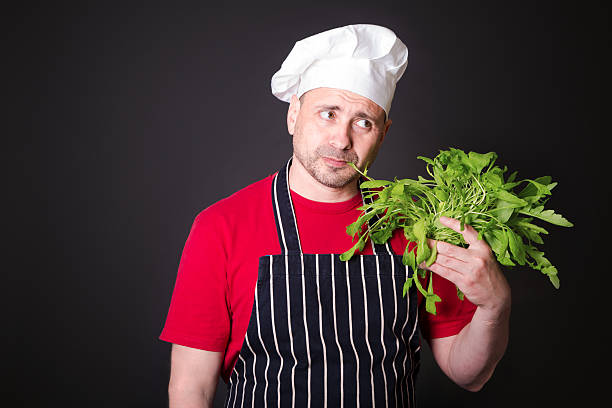 istock Closeup of happy chef holding arugula beam 635839950
