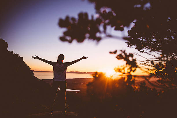 istock Women stretching out arms in sunrise 635840064