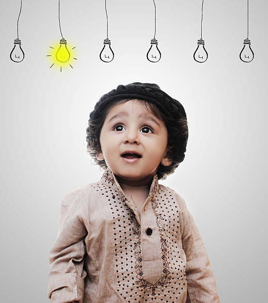 istock Adorable Intelligent Little Boy Thinking - Idea Bulbs 635845582