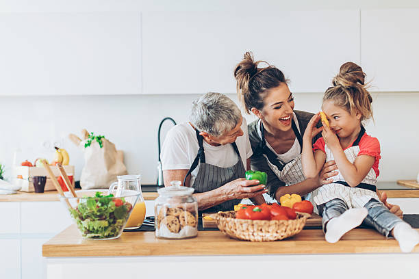 Three generations women in the kitchen Three-generation women - grandmother, mother and small girl having fun in the kitchen, with copy space. grandmother child baby mother stock pictures, royalty-free photos & images