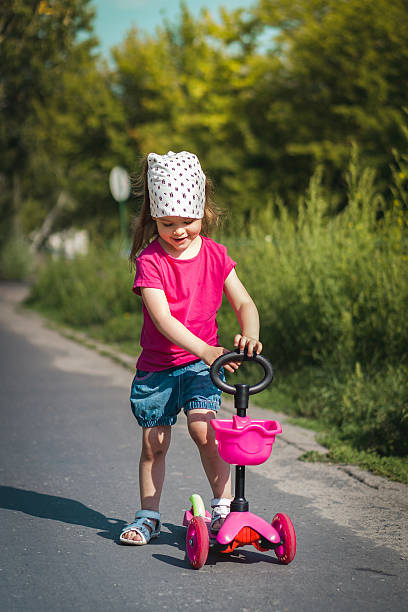 istock pretty girl standing on a scooter 635846734