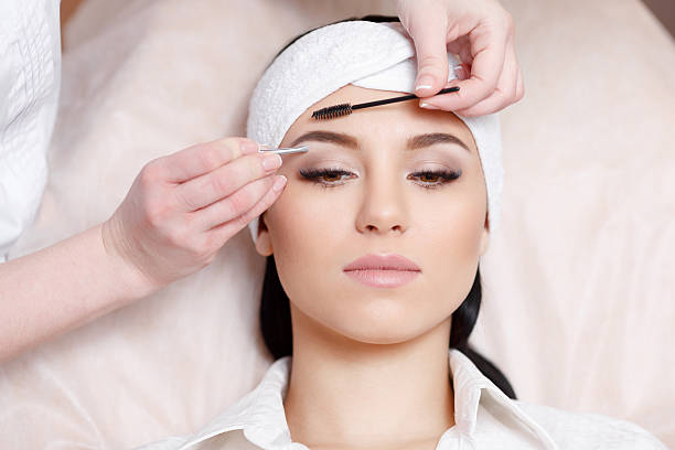 istock Beautiful young woman gets eyebrow correction procedure 635849402