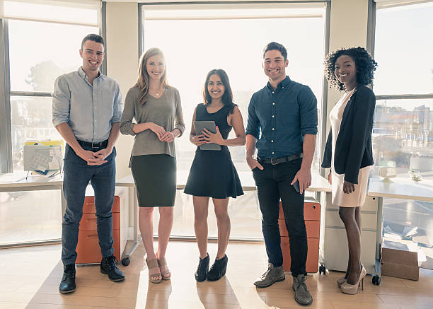 istock Five multi ethnic business people by office window, smiling 635850474