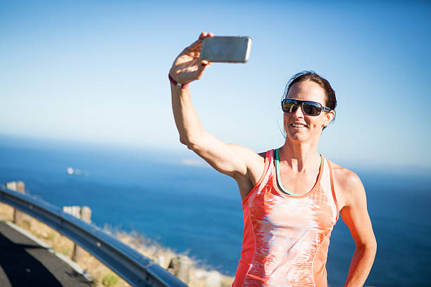 A sportswoman takes a selfie photo on her morning run, she is wearing sunglasses