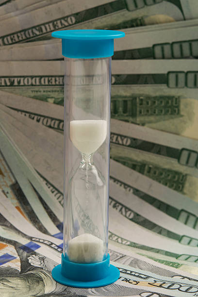 istock hourglass on the background of dollar bills 635863458