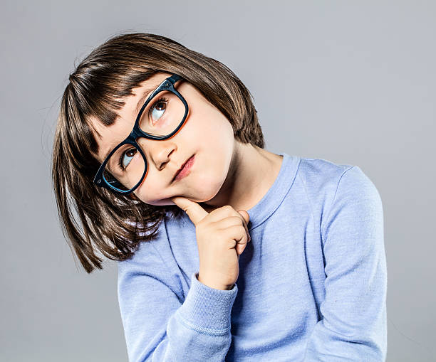 belle petite fille réfléchie avec des lunettes intelligentes à imaginer - child contemplation thinking little girls photos et images de collection