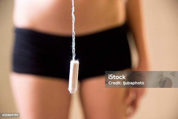 Girl Holding Tampon During The Monthly Cycle Stock Photo - Download Image Now - 20-29 Years, 2016, Abdomen