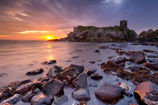 Spectacular sunrise at Kinbane Head with the ruins of Kinbane Castle on the Causeway Coast in Northern Ireland.