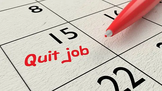 Red ballpen on a paper calendar closeup with the words quit job 3D illustration